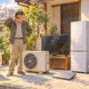 エアコンの室外機、テレビ、冷蔵庫、パソコン、原付を前に困る男性